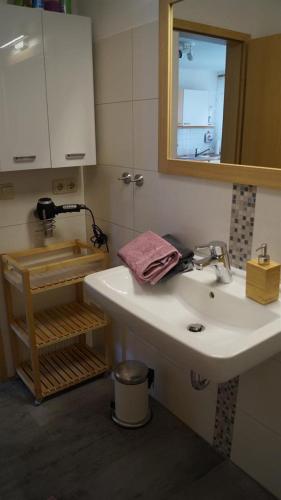 a bathroom with a sink and a mirror at Ferienwohnung Schlichting in Travemünde