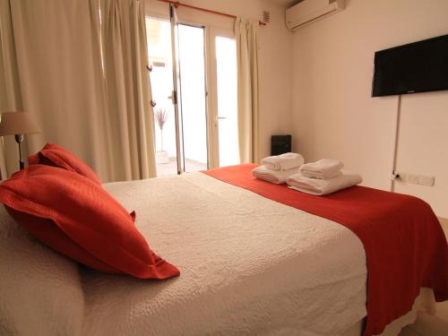 a bedroom with a bed with red pillows and a window at Piélago in Puerto Madryn