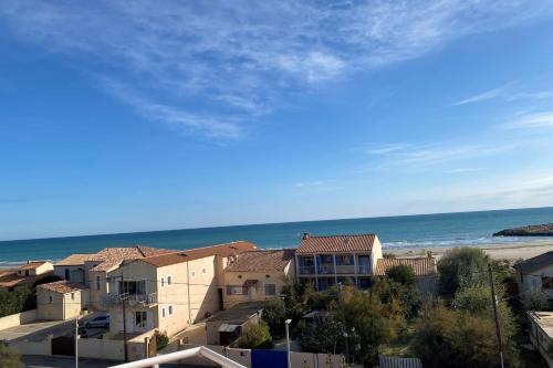 une vue sur la plage, les maisons et l'océan dans l'établissement A balcony overlooking the sea, à Frontignan