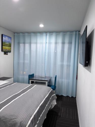 a bedroom with a bed and a table and a tv at Amber Lake C in Auckland