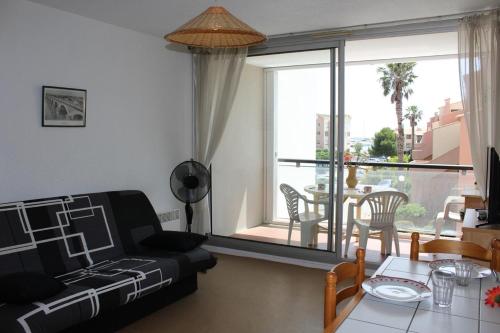 un salon avec un canapé et une table dans l'établissement Appartement Studio 2 couchages GRUISSAN GN400-236, à Gruissan