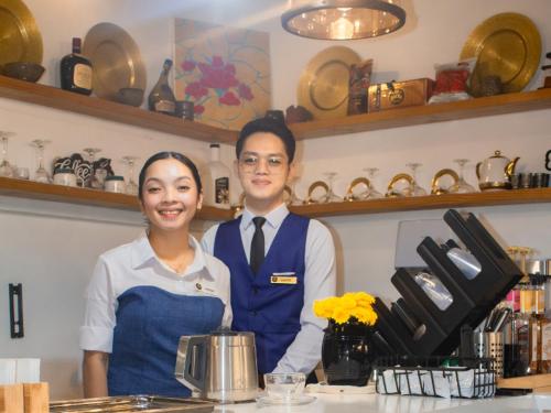 a man and a woman standing behind a counter at Gmb-Arte' Hotel in Sogod