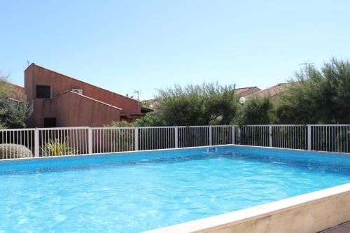 une grande piscine entourée d'une clôture. dans l'établissement Maison Studio Mezzanine - Gruissan GN530-013, à Gruissan