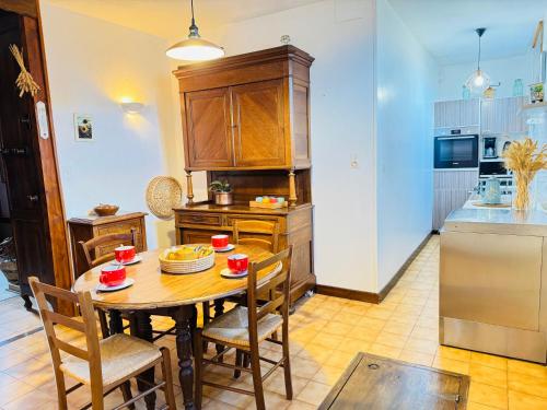- une cuisine avec une table et des chaises en bois dans la chambre dans l'établissement La Ferme du Croît - Proche Lacs & Observatoires, à Villehardouin