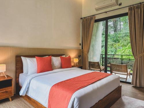 a bedroom with a large bed with red pillows at Arunika Villa in Ciloto