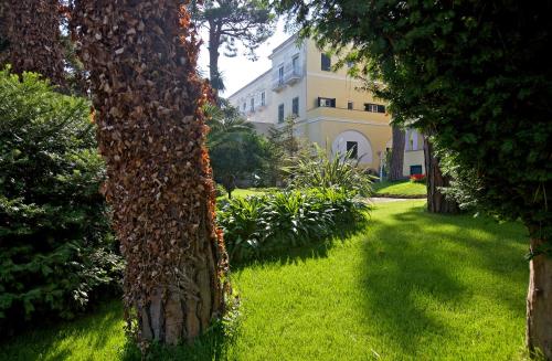 a group of trees in a yard with a building at Hotel San Michele in Anacapri