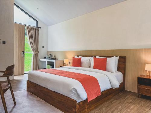 a bedroom with a large bed with red pillows at Arunika Villa in Ciloto