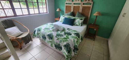 a bedroom with a bed with a green wall at 3 Lagoon Getaways in Southbroom