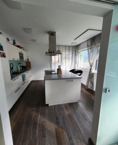 a kitchen with white cabinets and a wooden floor at Ferienhaus Mölltal in Penk