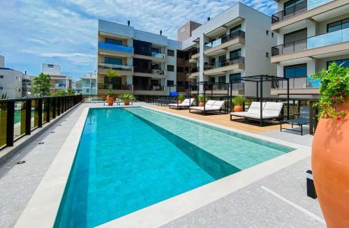 a swimming pool in front of a building at Apto em Home Clube na Praia de Palmas in Governador Celso Ramos