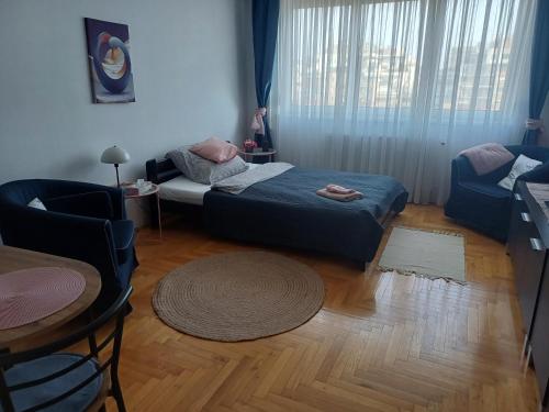 a bedroom with a bed and a chair and a table at Elisabeth7 Apartment in Budapest