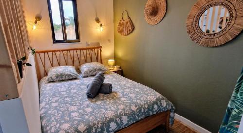 une chambre avec un lit avec des oreillers dessus dans l'établissement Villa Cosy - Proche Bordeaux, à Parempuyre