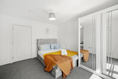 a bedroom with a bed and a mirror at Affordable 1 & 2 Bed Apartments in Slough, Great Heathrow Location in Colnbrook