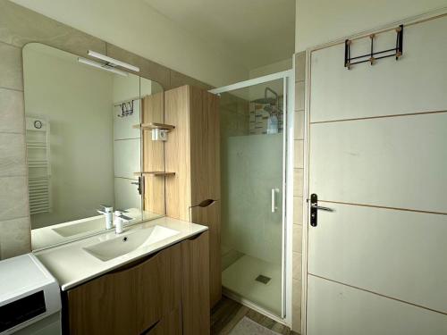 une salle de bain avec un lavabo, un miroir et une douche dans l'établissement Appartement Fréjus Plage - Port, à Fréjus