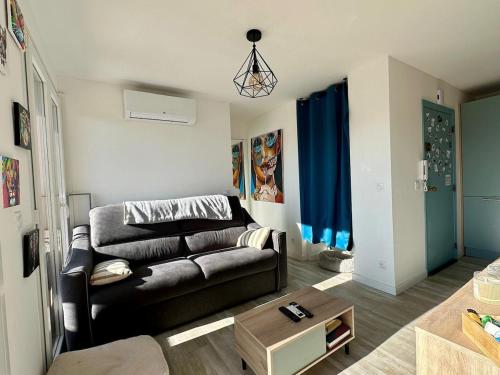 un salon avec un canapé et une table dans l'établissement Appartement Fréjus Plage - Port, à Fréjus