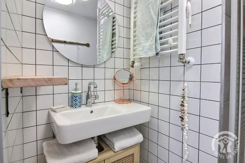 a white bathroom with a sink and a mirror at Chez mathieu et gaelle in Binic-Etables-sur-Mer