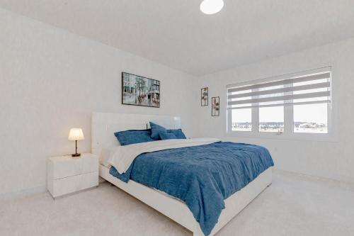 a white bedroom with a large bed and a window at Amazing Home in Niagra Region in Thorold