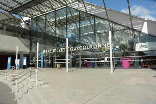 un bâtiment en verre avec un panneau indiquant la collaboration laitière dans l'établissement Grand Apt 4 Chambres - Terrasse - Moderne - Centre d'Evry, Évry-Courcouronnes