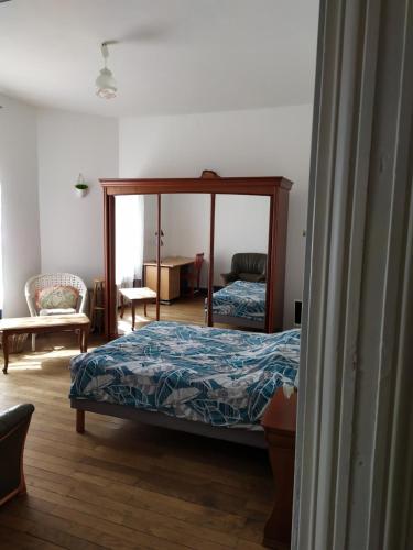 une chambre avec un lit et un miroir dans l'établissement Chambre dans maison bourgeoise 4, à Airvault
