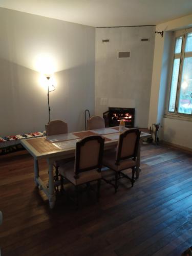 une salle à manger avec une table et des chaises et une cheminée dans l'établissement Chambre dans maison bourgeoise 4, à Airvault
