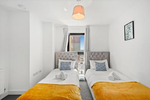 a bedroom with two beds and a window at Affordable 1 & 2 Bed Apartments in Slough, Great Heathrow Location in Colnbrook
