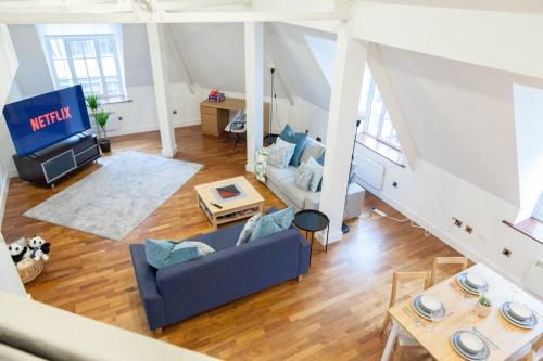 a living room with a blue couch and a tv at City Centre Penthouse Apartment in Leeds