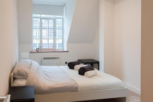 a bedroom with a bed and a window at City Centre Penthouse Apartment in Leeds