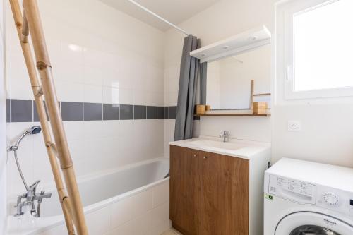 a bathroom with a sink and a washing machine at Chalet bois lac de Biscarrosse in Parentis-en-Born