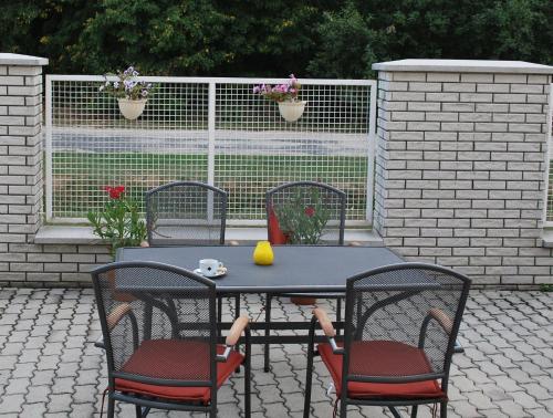 a table with four chairs and a table with a lemon on it at Főnix Hotel in Bük