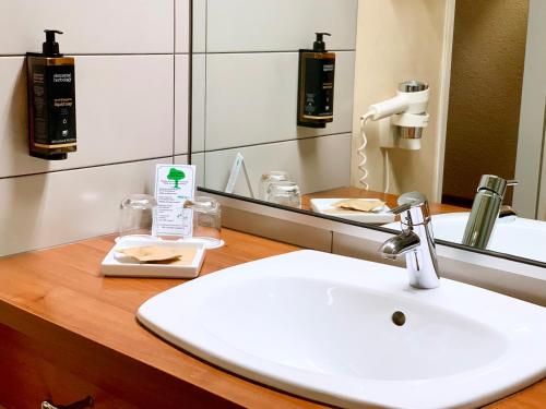a bathroom with a sink and a mirror at Mercure Hotel Hamburg am Volkspark in Hamburg