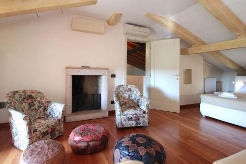 a living room with two chairs and a fireplace at Silea Apartments, Pool, Garden, Treviso in Silea