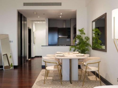 a kitchen with a table and chairs in a room at Elegant 1BR Full Palm View Apartment at 5 Star Resort in Dubai