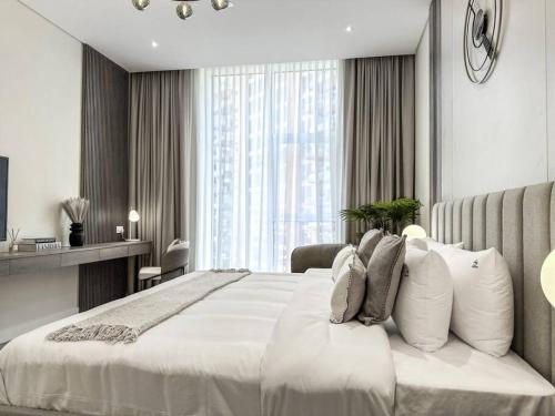 a bedroom with a white bed and a large window at Fantastic flat in TiaraResidence in Dubai