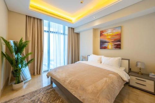 a bedroom with a large bed and a large window at Spacious beachfront 2 bedroom apartment - The 8 in Dubai