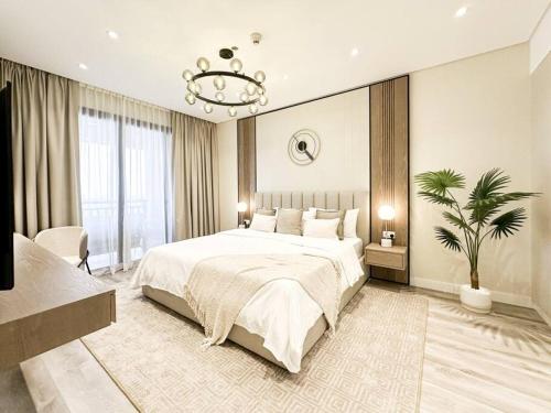 迪拜Upgraded Gorgeous 1BR at 5 Star Resort的一间带大床和吊灯的卧室
