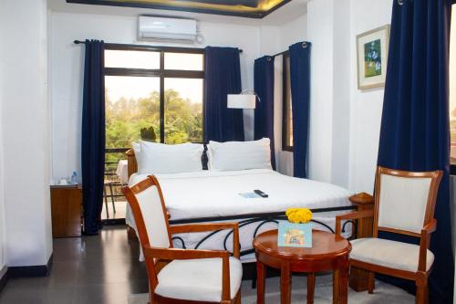 a bedroom with a bed and a table and chairs at Gmb-Arte' Hotel in Sogod