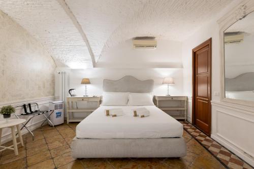 a bedroom with a white bed with two candles on it at Domus 15 - Guest House in Rome