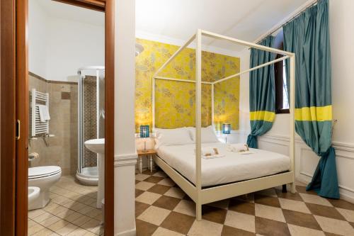 a bedroom with a canopy bed and a bathroom at Domus 15 - Guest House in Rome