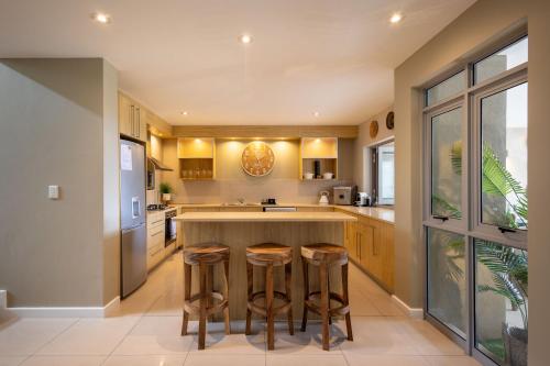 a kitchen with a island with bar stools at Kaya Anvi - Plettenberg Bay in Plettenberg Bay