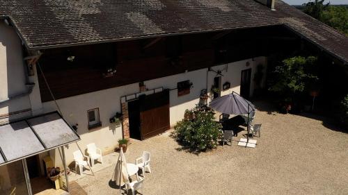 a courtyard of a building with a table and an umbrella at La Ferme du Croît - Proche Lacs & Observatoires in Villehardouin
