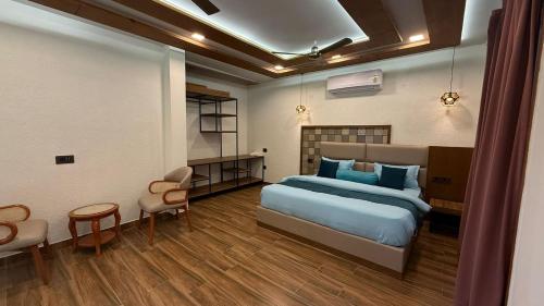 a bedroom with a bed and a table and chairs at Yes Hotel By The Ganges in Rishīkesh