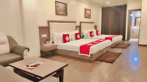a hotel room with two beds and a couch at Hotel The Royal Krishna in Katra