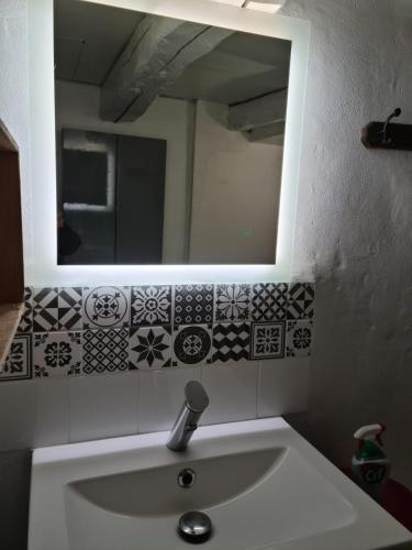une salle de bain avec un lavabo et un miroir dans l'établissement La Petite Betoulle, à Bussière-Saint-Georges