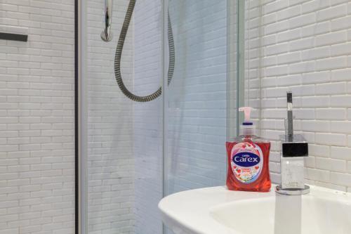 a bathroom with a bottle of cleaner on a sink at City Centre Penthouse Apartment in Leeds