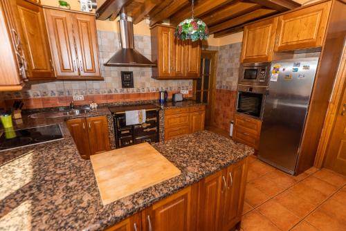 a kitchen with wooden cabinets and stainless steel appliances at Casa la Campa in Cardes