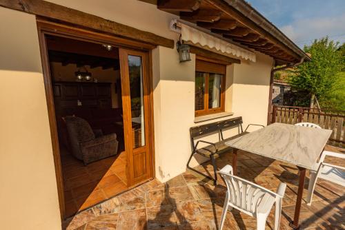 a patio with a table and chairs on a house at Casa la Campa in Cardes
