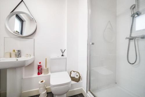 a white bathroom with a toilet and a shower at Affordable 1 & 2 Bed Apartments in Slough, Great Heathrow Location in Colnbrook