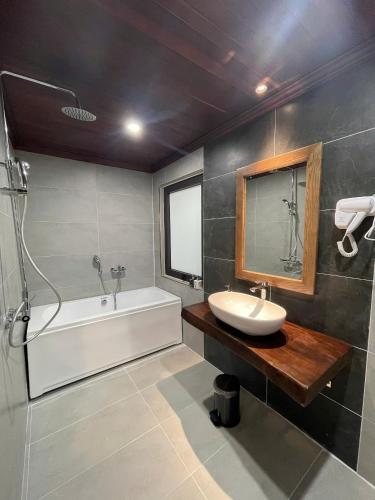 a bathroom with a sink and a tub and a mirror at Luang Prabang Dream 1985 in Luang Prabang