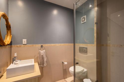 a bathroom with a sink and a toilet and a shower at Kaya Anvi - Plettenberg Bay in Plettenberg Bay