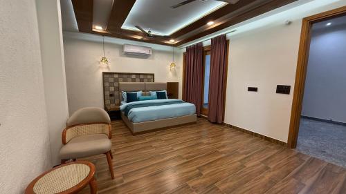 a bedroom with a bed and a table and chairs at Yes Hotel By The Ganges in Rishīkesh